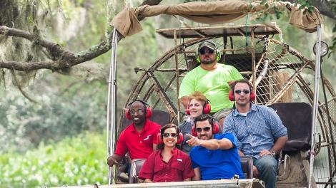 A swamp tour sets off under a canopy of Spanish moss