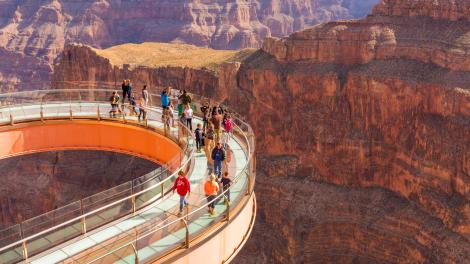 Visitantes disfrutando de las asombrosas vistas en el piso de cristal del Grand Canyon Skywalk