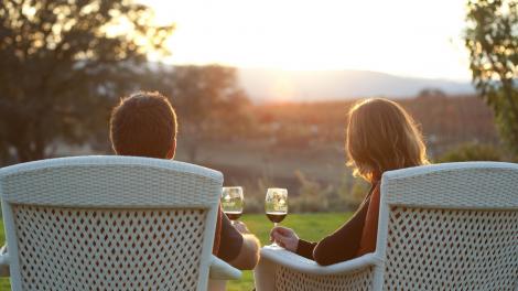 Couple sipping wine while taking in vineyard views 