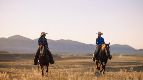 Riding horses through the wide-open grasslands near Buffalo