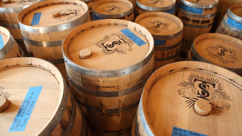 装满 Troy & Sons 的摩闪酒(或称为“白色威士忌”)在 Asheville Distilling Co. 公司等待罐装北卡罗来纳州,阿什维尔 装满 Troy & Sons 的摩闪酒(或称为“白色威士忌”)在 Asheville Distilling Co. 公司等待罐装北卡罗来纳州,阿什维尔