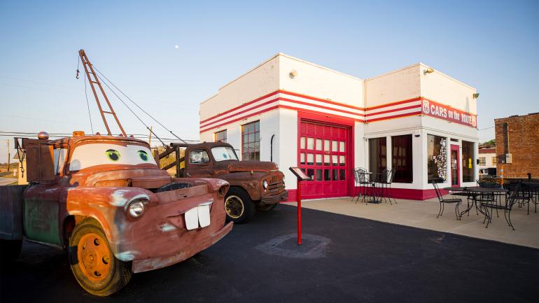 Boom trucks that inspired the Pixar character Tow Mater stand outside Cars on the Route in Galena