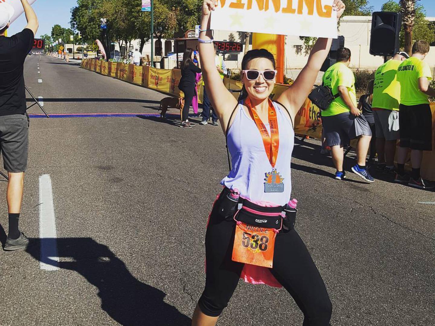 A runner celebrates completing the annual Gilbert Half Marathon road race in Arizona