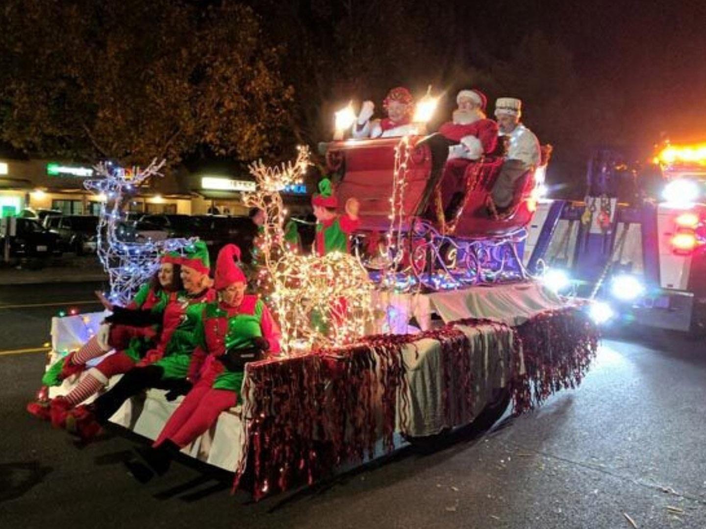 Der Weihnachtsmann mit seiner Frau auf einem festlich geschmückten Wagen bei der Holiday Light Parade in Paso Robles, Kalifornien