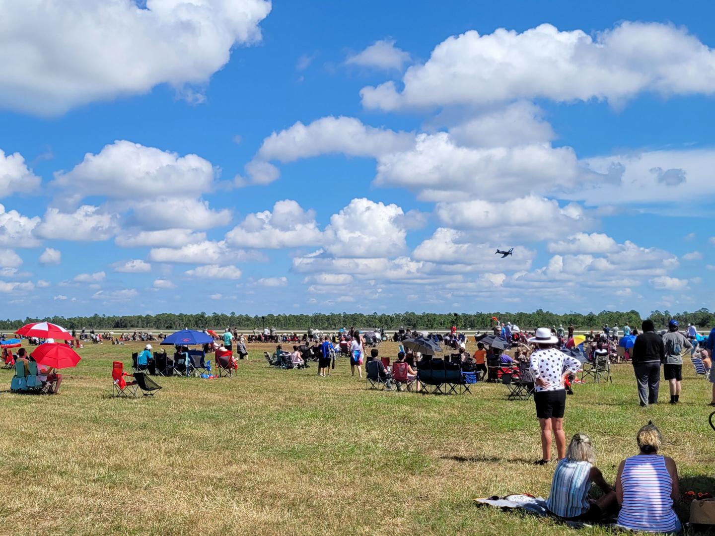 A crowd watches a plane fly over Punta Gorda Airport at the Florida International Air Show