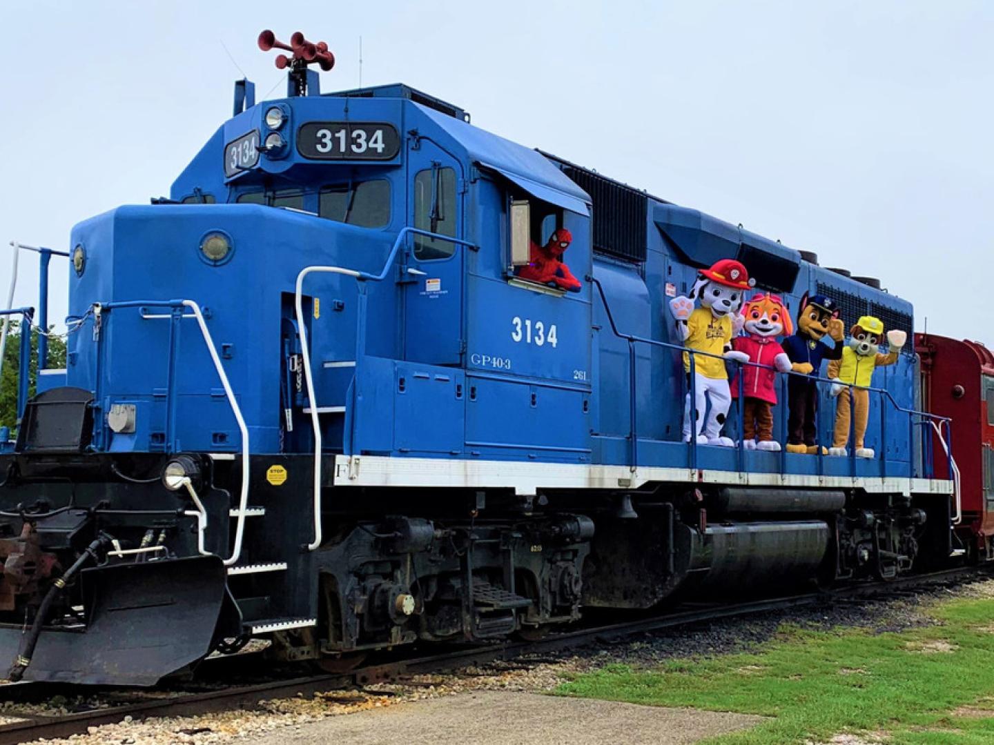 Costumed characters pose on a Greater Austin Steam Train Association locomotive during Greater Austin Comic Convention in Cedar Park, Texas
