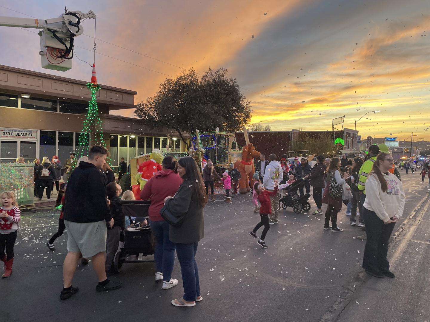 Visitantes disfrutando de las luces navideñas y la nieve artificial en Very Merry Street of Lights en el centro de Kingman, Arizona