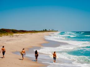 Surfers strolling along one of the area’s 115 kilometers of beaches
