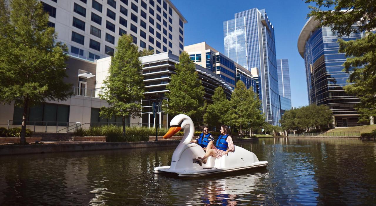 在德克萨斯州伍德兰的 Woodlands Waterway 河道中蹬天鹅船 在德克萨斯州伍德兰的 Woodlands Waterway 河道中蹬天鹅船