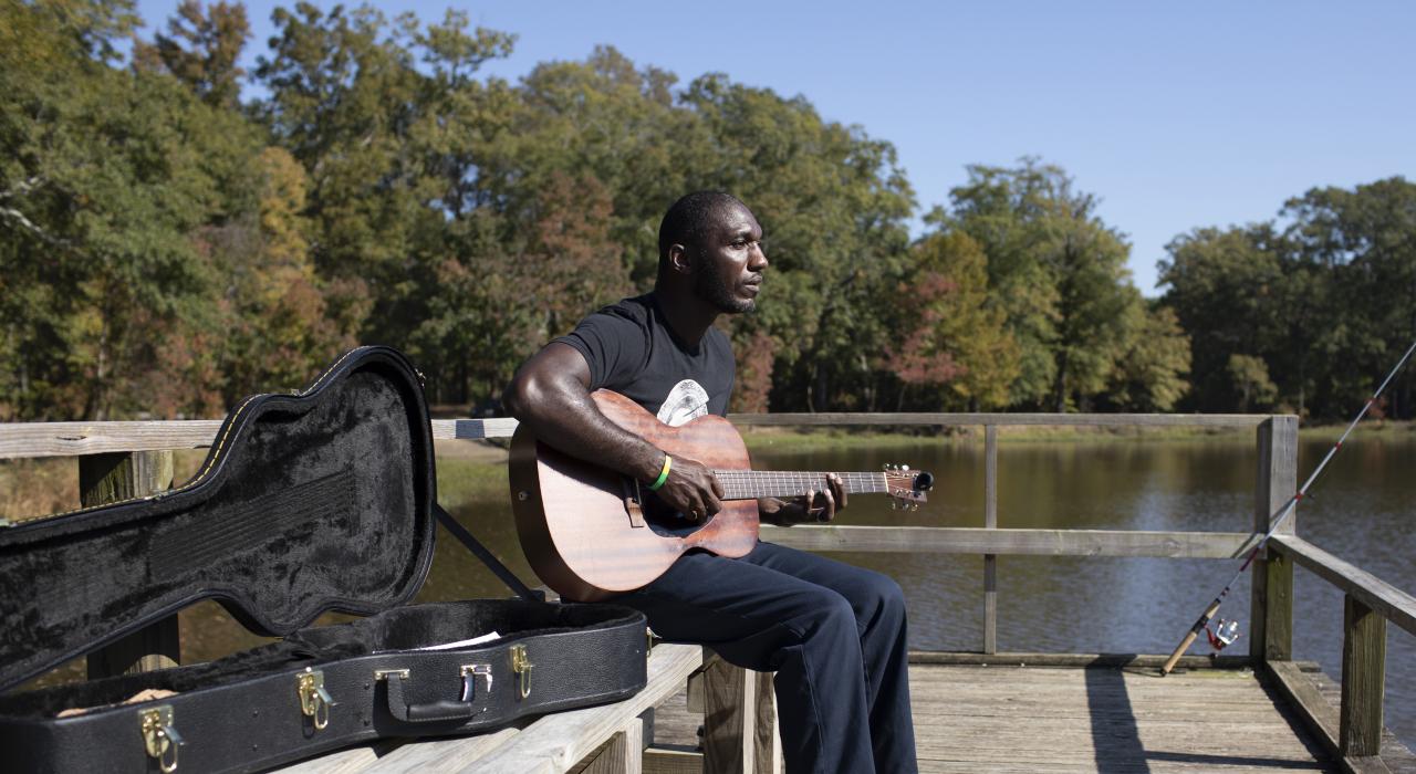 À Jackson, dans le Mississippi, Cedric Burnside s’arrête pour jouer de la guitare entre deux lancers de pêche