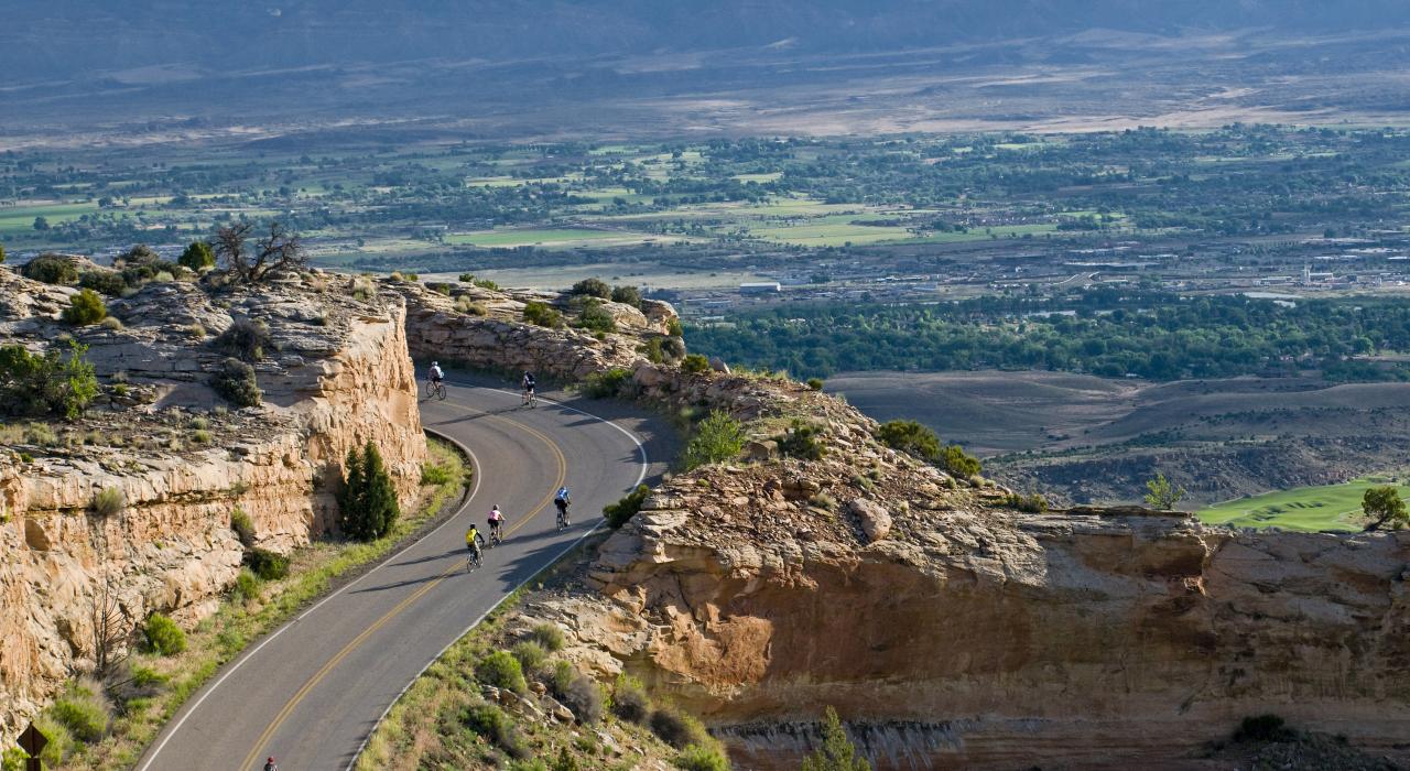 자전거를 타고 콜로라도주 그랜드정크션과 가까운 콜로라도 국립 기념지 지나기